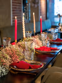 overview dinertafel met gipskruidslinger , borden met gouden rand, en roze servetten en kaarsen