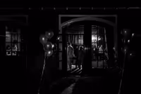 zwart wit foto van ingang feestzaal met gasten binnen